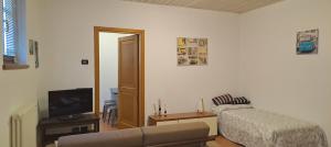 ein Wohnzimmer mit einem Sofa und einem TV in der Unterkunft Apartment Lake Maggiore - Gabella in Maccagno Inferiore