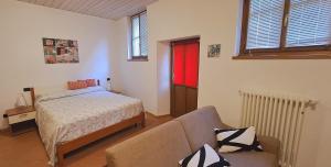 ein Schlafzimmer mit einem Bett und einem Sofa in der Unterkunft Apartment Lake Maggiore - Gabella in Maccagno Inferiore