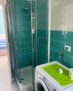 a green bathroom with a shower and a washing machine at Case Vacanza Da Silvì in Agropoli