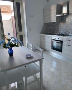 a kitchen with a table with a vase of flowers on it at Case Vacanza Da Silvì in Agropoli