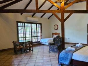 ein Schlafzimmer mit 2 Betten und einem Tisch in einem Zimmer in der Unterkunft Arum Lily Eloff in Delmas