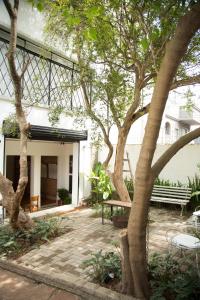 a patio with a bench and trees in front of a building at Guest Urban Hotel Design Pinheiros in São Paulo