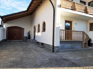 Casa blanca con balcón y entrada en Ferienwohnungen Geier, en Niederalteich
