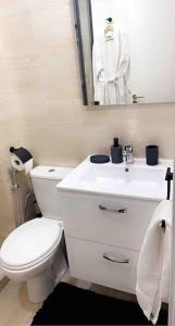 La salle de bains est pourvue de toilettes blanches et d'un lavabo. dans l'établissement Prestigia Golf entrée Agate (wifi), à Marrakech