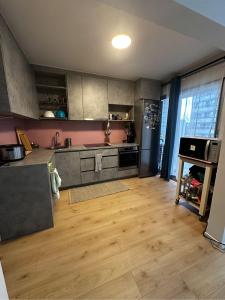 a kitchen with wooden floors and stainless steel appliances at Alexanor Cosy Private Room in a Shared Apartment in Brussels