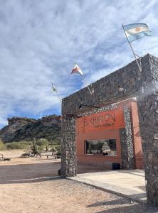 um edifício com duas bandeiras em cima em El Chiflon Posta Pueblo em El Chiflón