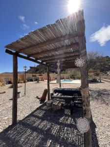 uma pérgola de madeira ao lado de uma piscina em El Chiflon Posta Pueblo em El Chiflón