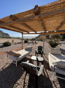 a group of furniture under a wooden pergola at El Chiflon Posta Pueblo in El Chiflón