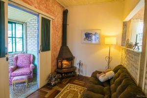 a living room with a couch and a fireplace at Pousada Villa Allegra in Tiradentes