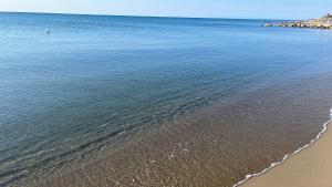 um corpo de água com uma praia de areia e o oceano em Villaggio Mondial Camping em Metaponto