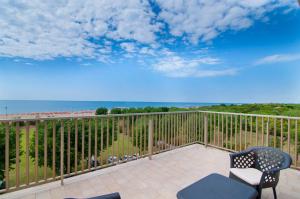 a balcony with chairs and a view of the beach at Centro Vacanze Opera Nascimbeni in Cavallino-Treporti