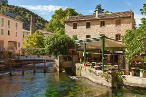un restaurante junto a un río en una ciudad en Détours en Provence - Lavande 3*, en Châteaurenard