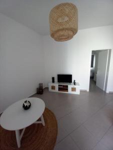 Mariam House في باريكيا: غرفة معيشة بيضاء مع طاولة وتلفزيون