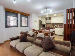a living room with a couch and a kitchen at BHost - María Auxiliadora in Córdoba