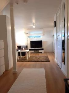 un salon avec une télévision et une table dans l'établissement By the sea apartment, à Stavanger