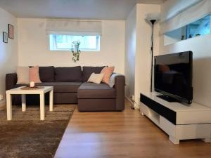 Il comprend un salon doté d'un canapé et d'une télévision à écran plat. dans l'établissement By the sea apartment, à Stavanger