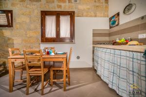uma cozinha com mesa e cadeiras e um balcão em Casa vacanze Peperoncino em Castellammare del Golfo