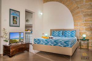 um quarto com uma cama e uma televisão num quarto em Casa vacanze Peperoncino em Castellammare del Golfo