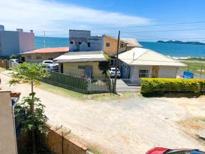 a house with a fence in front of the ocean at Casinha Quadra Mar a 10 min do Beto Carrero! in Penha