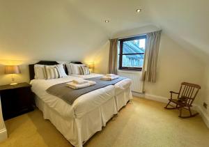 a bedroom with a large bed with towels on it at Poppy Cottage - Cornwall in Saint Wenn