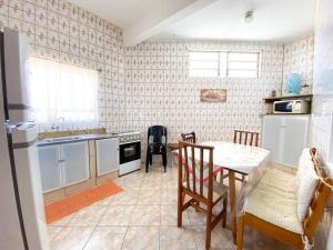 a kitchen with a table and chairs and a dining room at Casinha Quadra Mar a 10 min do Beto Carrero! in Penha