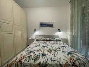 una camera da letto con un letto con copriletto floreale di Mari Sole By Holiday World a Chiavari