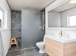 Cozy Cottage With Wilderness Bath في Føllenslev: حمام مع حوض ومرحاض