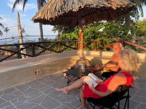 Ein Mann und eine Frau, die an einem Tisch unter einem Schirm sitzen in der Unterkunft Red Sands Pool Villa in Phan Thiet