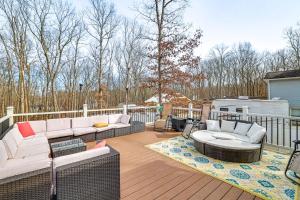 a patio with couches and tables on a deck at Poconos Home with Private Pool, Hot Tub and Sauna! in East Stroudsburg