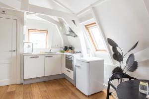 アムステルダムにあるNuma Amsterdam Helmersの小さなキッチン(白いキャビネット、テーブル付) +34枚の写真