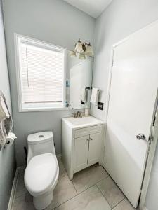een witte badkamer met een toilet en een wastafel bij Contemporary 1 BR House with Pool - MK2 - WW in Los Angeles