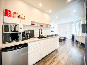 a large kitchen with white cabinets and appliances at Cozy Studio Retreat with Shared Pool - MK4-WW in Los Angeles