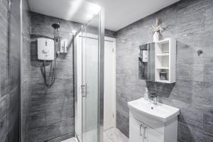 uma casa de banho com um chuveiro, um WC e um lavatório. em Beautiful Apartment tres em Litherland