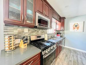 a kitchen with wooden cabinets and a stove top oven at Modern 2BR Apartment in Heart of the City-MK1-WW in Los Angeles