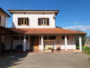 una casa blanca con techo rojo en Magnolie, en Castiglion Fiorentino