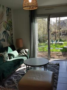 sala de estar con sofá y mesa en La Maison Olivia, en La Rivière-Saint-Sauveur