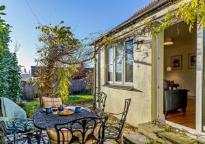 a patio with a table and chairs in a yard at Wisteria House in Camelford