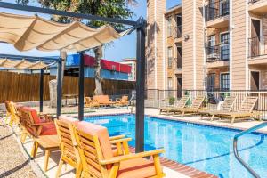 a swimming pool with lounge chairs and a swimming poolvisor at COZY LONG TERM APT WITH POOL ACCESS IN DFW in Dallas