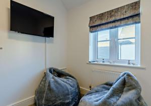 a living room with two chairs and a flat screen tv at Wisteria House in Camelford