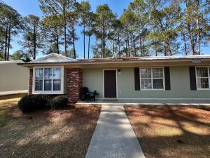a small white house with a driveway at Southern Travel - Charming 3 Bedroom in Moultrie