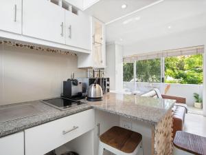 a kitchen with white cabinets and a counter top at Fairmile Urban Oasis in Cape Town