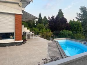 a backyard with a swimming pool and a patio at Chambre dans jolie nature in Auxi-le-Château