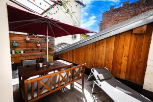 un patio con una valla de madera y una mesa con sombrilla en Cozy apartment in heart of Maribor / big terrace en Maribor