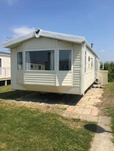 a mobile home is sitting on the grass at MP39 Parkdean Camber Sands in Camber