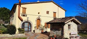 een groot wit huis met een stenen gebouw bij Tenuta Le Garzaie - Villa Furlo in Fermignano