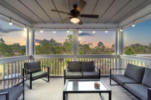 a screened in porch with couches and a ceiling fan at Living In Luxury in Pensacola