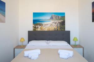 a bedroom with a bed with a painting on the wall at Appartamenti Leone1 in San Vito lo Capo