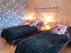 a bedroom with two beds and a wall with flowers at La Maison des Senteurs in Francorchamps