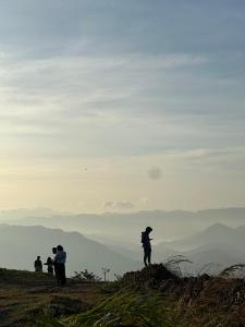 grupa ludzi stojących na szczycie wzgórza w obiekcie Sunset Valley Kerala - Where Every Evening Unveils a Perfect Sunset with Private Waterfalls w mieście Pīrmed