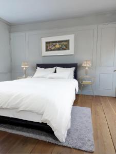 una camera con un grande letto bianco e un tappeto di Townhouse near Spitalfields Market a Londra